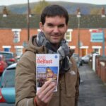 Man holding brochure saying 'visit Belfast'
